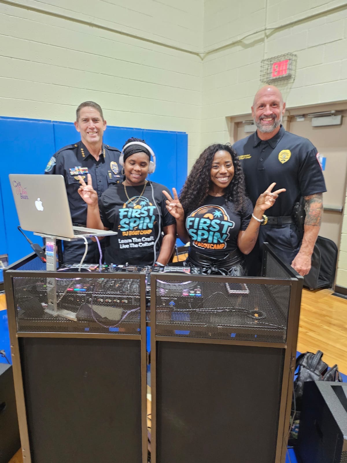 DJ ReRe and a First Spin student with two Hollywood Police officers at the DJ system.